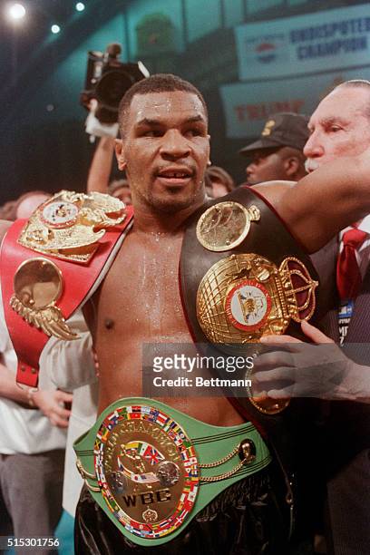 Atlantic City, NJ- Unquestionably the heavyweight champion of the world, Mike Tyson shows off his 3 championship belts -- the WBC, WBA, and IBF --...
