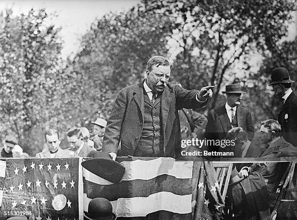 Theodore Roosevelt standing on a podium pointing into the crowd during a campaign rally speech. Ca. 1900s.