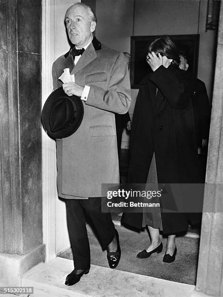 London-Still playing it secret, former screen star Greta Garbo covers her face as she leaves the residence of British Prime Minister Sir Anthony Eden...