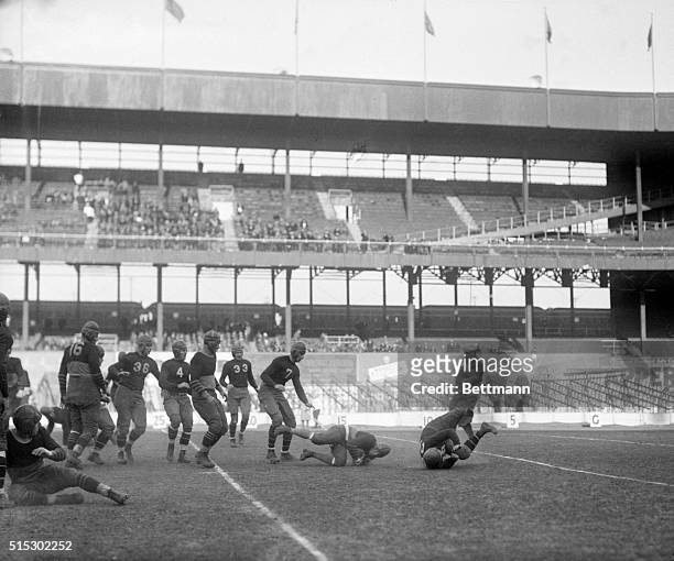 New York, NY-Ernie Nevers, Cardinal star, squirms his way along the ground for a gain in the football match between the New York Giants and the...