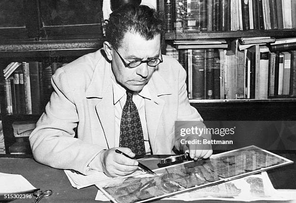 Professor Eleazer L. Sukenik, Dir. Of the Hebrew University' Museum of Jewish Antiquities, studies a fragment of one of the ancient Hebrew Scrolls...