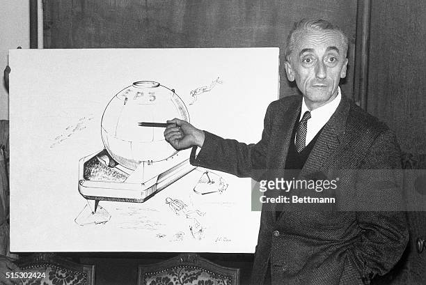 Nice, France -: Pointing to a rendering of his "Spheric Submarine Base" design, Jacques Cousteau explains how five men will spend the night...