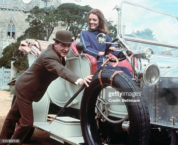 Diana Rigg as Mrs. Emma Peel on the British spy series, "The Avengers." She is shown at the wheel of a car which is being pushed by co-star Patrick...