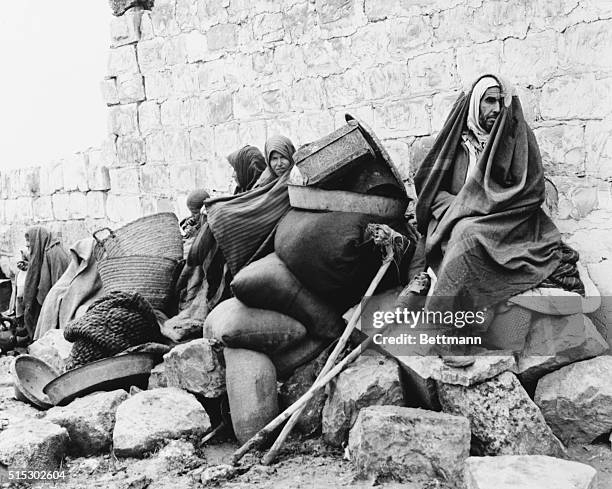 Disabled Arab civilian with his improvised crutches waits with other Arabs in the Al Fajula area, for the arrival of the trucks that will take them...