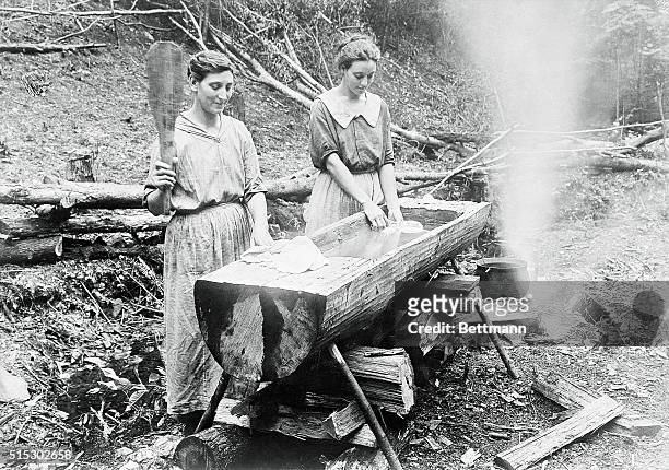 Ca. 1880-Tennessee- Laundry in its primitive stage. Two women pounding and washing clothes in wooden trough in the farm district.