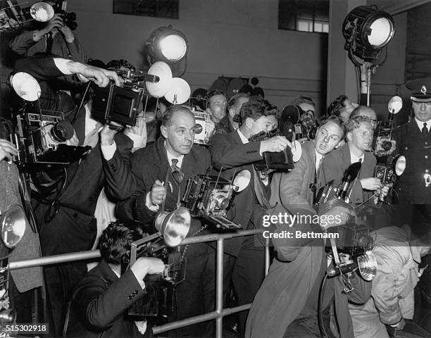 London, England Actress Marilyn Monroe posed happily for a battery of photographers, shortly after arriving at London's airport yesterday with her...