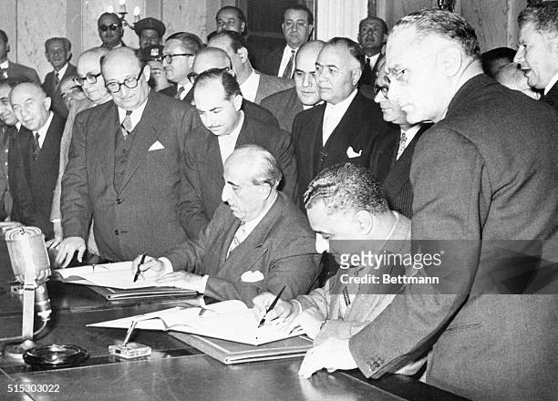 Cario, Egypt- Egyptian President Gamal Abdel Nasser and Syrian President Shukri El-Kuwatly sign the official proclamation merging their two nations...