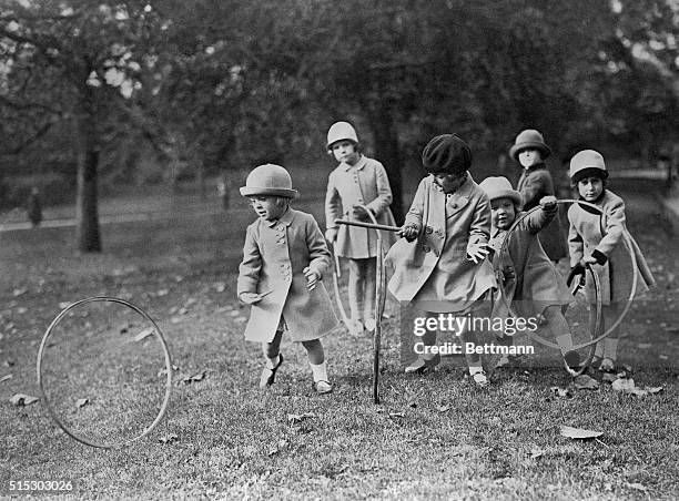 Young children play with hoops in the park. Undated photograph, circa 1930's.
