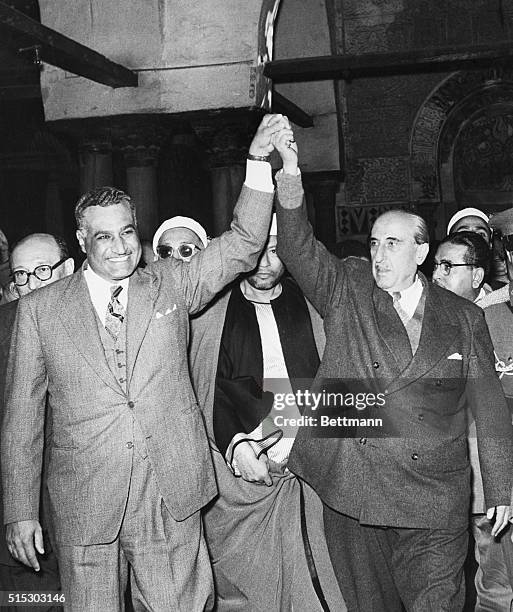 Cairo, Egypt- Egyptian President Gamal Abdel Nasser, left, and Syrian President Shukri Al-Kuwatly clasp hands to symbolize merger of the two...