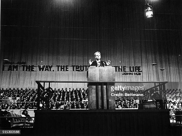 London, England- With the words, "Jesus said, I am the way, the truth and the life," as a backdrop, Billy Graham speaks to a large congregation...