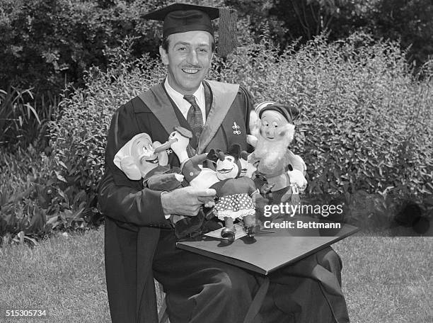 Walter E. Disney, famous producer of animated cartoons, is shown with doll replicas of his most famous characters which were responsible for his...