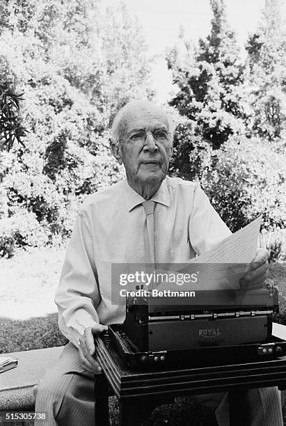 Muckraking author and journalist Upton Sinclair, author of The Jungle, sits outside with a typewriter.