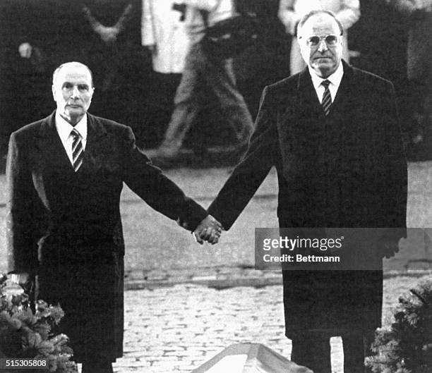 Verdun, France- French President Francois Mitterrand and West German Chancellor Helmut Kohl hold hands while the national anthems of both countries...
