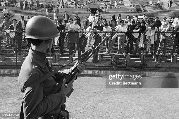 Soldier in the Chilean Army stands guard over political prisoners held at the National Stadium in Santiago. On September 11 the Chilean Army...