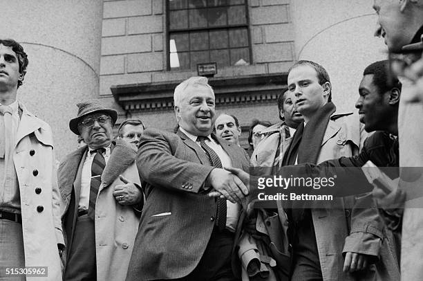 Israeli Minister of Trade and Industry Ariel Sharon shakes hands with a well-wisher as he emerges from Federal Court in New York City in 1985 after...
