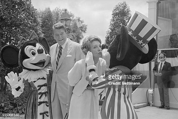 Epcot Center, Florida: First Lady Nancy Reagan kisses Mickey Mouse as President Reagan and Minnie Mouse watch. The Reagans were at EPCOT Center 5/27,...