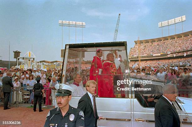 Los Angeles: Pope John Paul II waves to the crowd at Dodger stadium as he is driven around the facility.