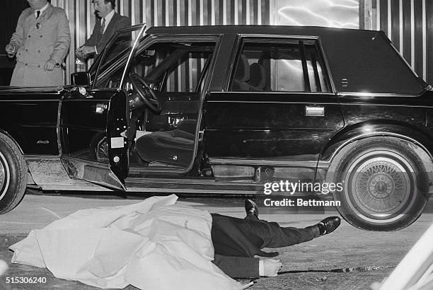 The body of Thomas Bilotti, underboss to Paul "Big Paul" Castellano of the Gambino crime family, lies alongside his car after being gunned down...