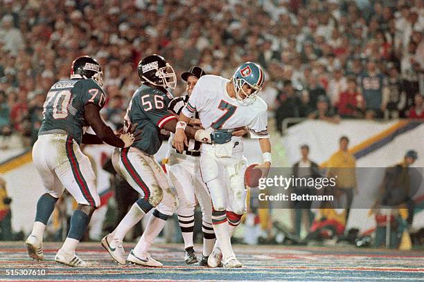 Bronco Quarterback John Elway looks like a rag doll 1/25 in hands of Giant linebacker Lawrence Taylor in 4th quarter end zone play the ref is...