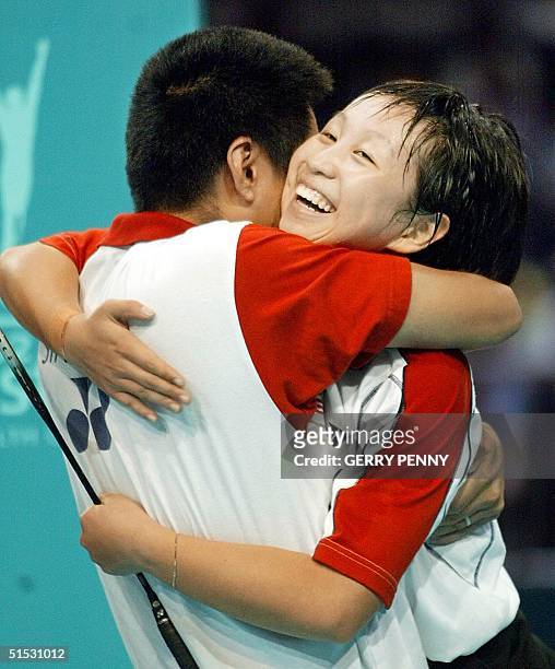 Li Li from Singapore is hugged by her Chinese coach Qingwu Zhang after winning the gold medal 04 August 2002, in the Commonwealth Games Badminton...