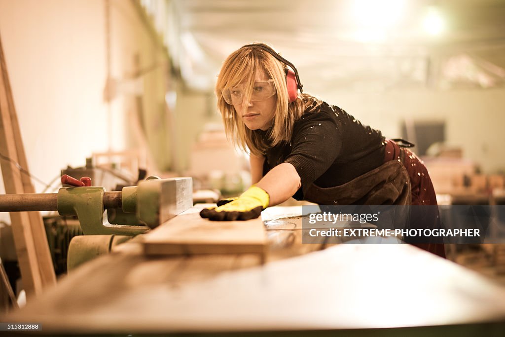 Blonde woman using plank cutter