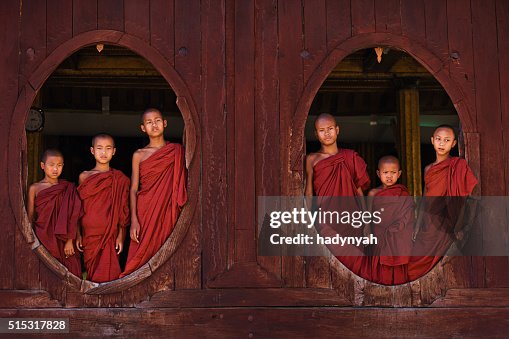Novice Buddhist monks posing in the window of monastery Novice Buddhist monks posing in the window of monastery