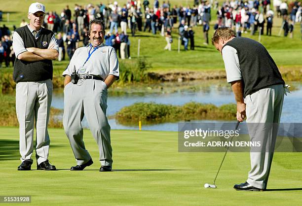 European team Captain Sam Torrance reacts to a joke as Phillip Price , of Wales, watches Pierre Fulke , of Sweden, hit a putt on the 18th hole during...