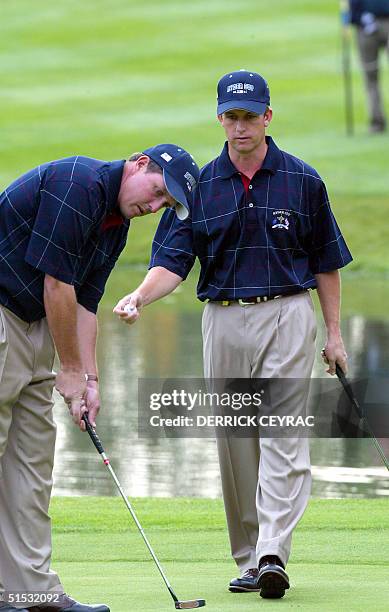 Team Ryder Cup golfers Phil Mickelson and David Toms studies the putting line on the green of 12th hole during second round four ball matches...