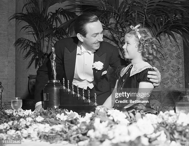 Los Angeles, CA- Shirley Temple presents an Academy Award to Walt Disney for his outstanding cartoon, "Snow White and the Seven Dwarfs," one big...