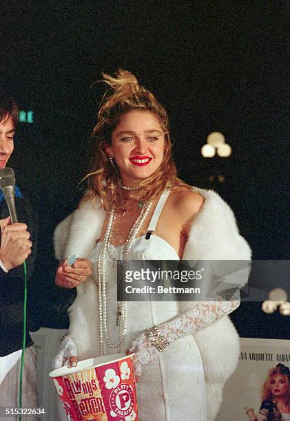 Century City, California: Madonna attends opening of her film Desperately Seeking Susan. Photo shows Madonna, dressed in white and holding a bucket...