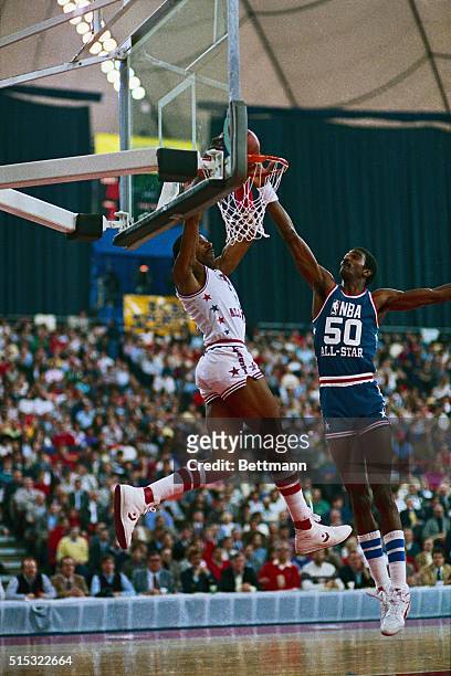 Eastern Conference All Star drives for layup past defender Western Conference's Ralph Sampson in first half of the NBA All Star Game 2/10.