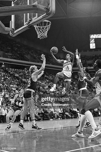 Spud Webb, the 5-foot 7-inch guard for the Atlanta Hawks, flies past Celtic defenders Larry Bird and Dennis Johnson on his way to two points during...