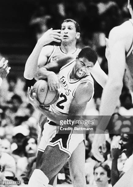 Magic Johnson of the Los Angeles Lakers takes a rebound from Portland Trailblazers' Sam Bowie during a basketball game in Inglewood, California.