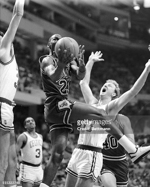 Chicago Bulls' Michael Jordan crashes into Celtics' Larry Bird as he goes up for two points during 1st quarter action of their playoff game at Boston...