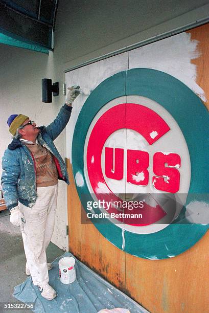 Chicago, Illinois: Painter Andres Hernandez applies primer before repainting a faded Cubs' logo at Wrigley Field March 28 in preparation for home...