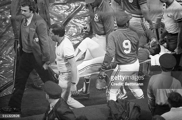 Covering his face with his hand, the Cardinals rookie speedster Vince Coleman is carried off the field with the help of teammates Terry Pendleton and...