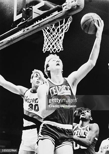 Larry Bird of the Boston Celtics scores over Sam Bowie of the Portland Trailblazers during a basketball game in Portland, Oregon.