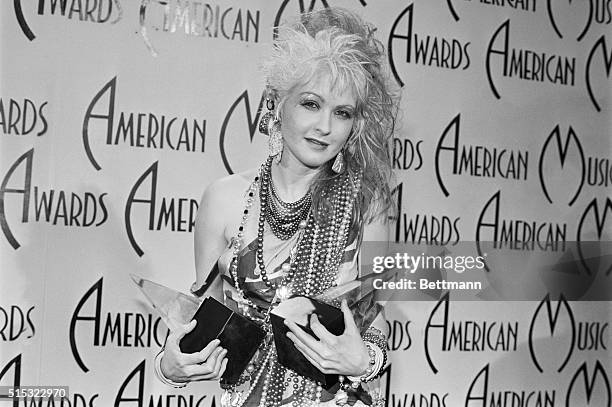 Pop star Cyndi Lauper holds her two American Music Awards, which she won for Favorite Female Artist Pop/Rock and Favorite Female Video Artist...