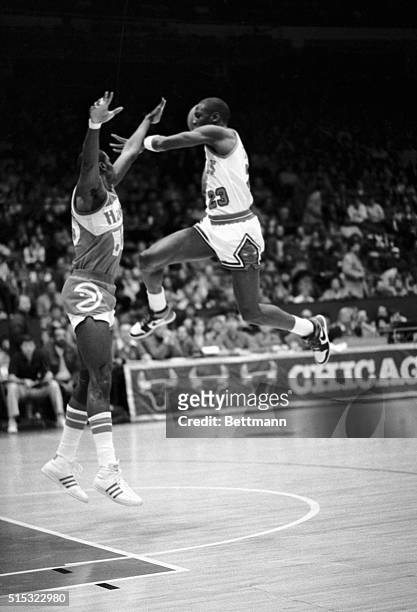 Bulls' Michael Jordan leaps high trying to get over Cliff Levingston of the Atlanta Hawks in the first half at Chicago Stadium 1/26. Jordan passed...