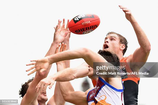 Heath Shaw of the Giants competes for the ball against Jonathan Freeman and Daniel McStay of the Lion during the NAB Challenge AFL match between the...