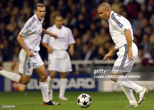 French Real Madrid player Zinedine Zidane looks at his Brazilian teammate Ronaldo in action during the match against AEK Athens for the European...