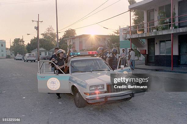 Miami: Riot-equipped police still patrol the streets of the Overtown section of town as the sun comes up 1/17, the day after hours of rioting,...