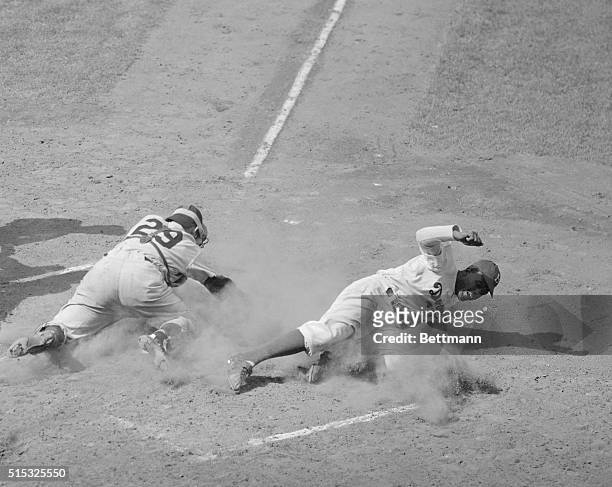 Jackie Robinson , Brooklyn Dodgers second baseman, steals home in the first inning of the Dodgers-Yankees game, at Ebbets Field. At left is Yankee's...
