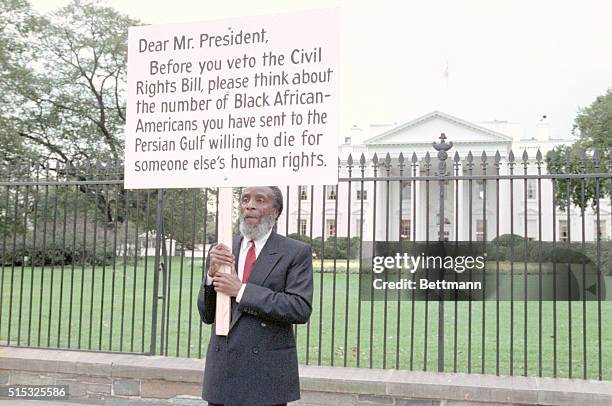 Washington: Activist Dick Gregory holds a placard outside the White House as he urges President Bush to sign 1990 Civil Rights Bill passed by...