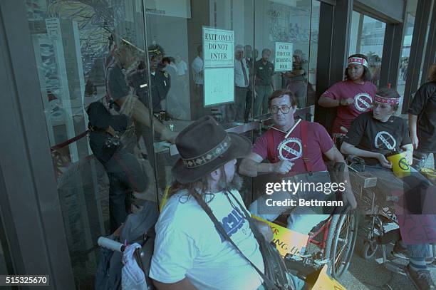 Atlanta: Disabled activist John Clayton, from Houston , locks his neck to the door at the Richard B. Russell Federal Building as he and about 100...