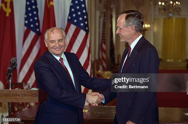 Washington: President Bush and Soviet President Gorbachev reach to shake hands after announcing a series of new agreements in a White House ceremony...