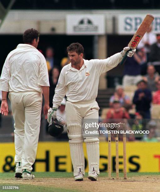 Australian captain Mark Taylor salutes his home crowd as he is congratulated by English pace seamer Angus Fraser for his century during the final...