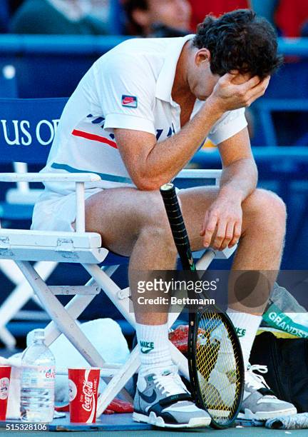 New York: John McEnroe's racquet falls as he holds his head during a break in his U.S. Open semifinal with Pete Sampras. McEnroe lost the first two...