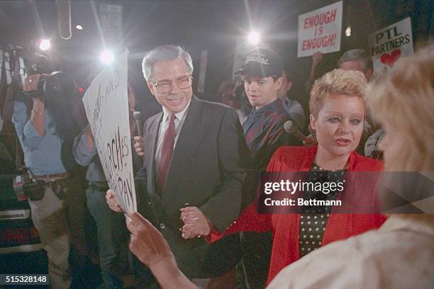 Charlotte, N.C.: PTL founder Jim Bakker, L, his son, Jamie, and wife, Tammy Faye Bakker, greet supporters as they leave federal court in Charlotte....