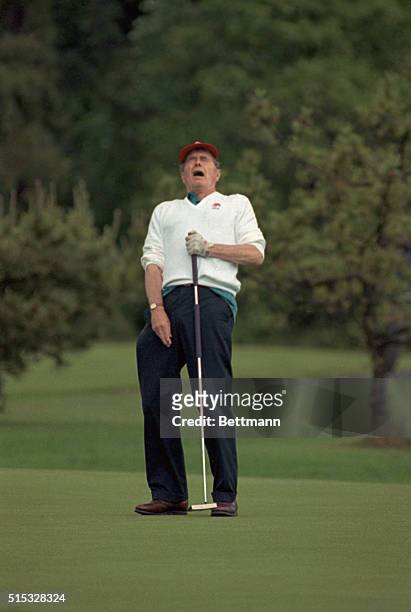 Andrews Air Force Base, Md.: President Bush reacts to a missed putt on the 18th hole during a round of golf at Andrews Air Force Base. The President...